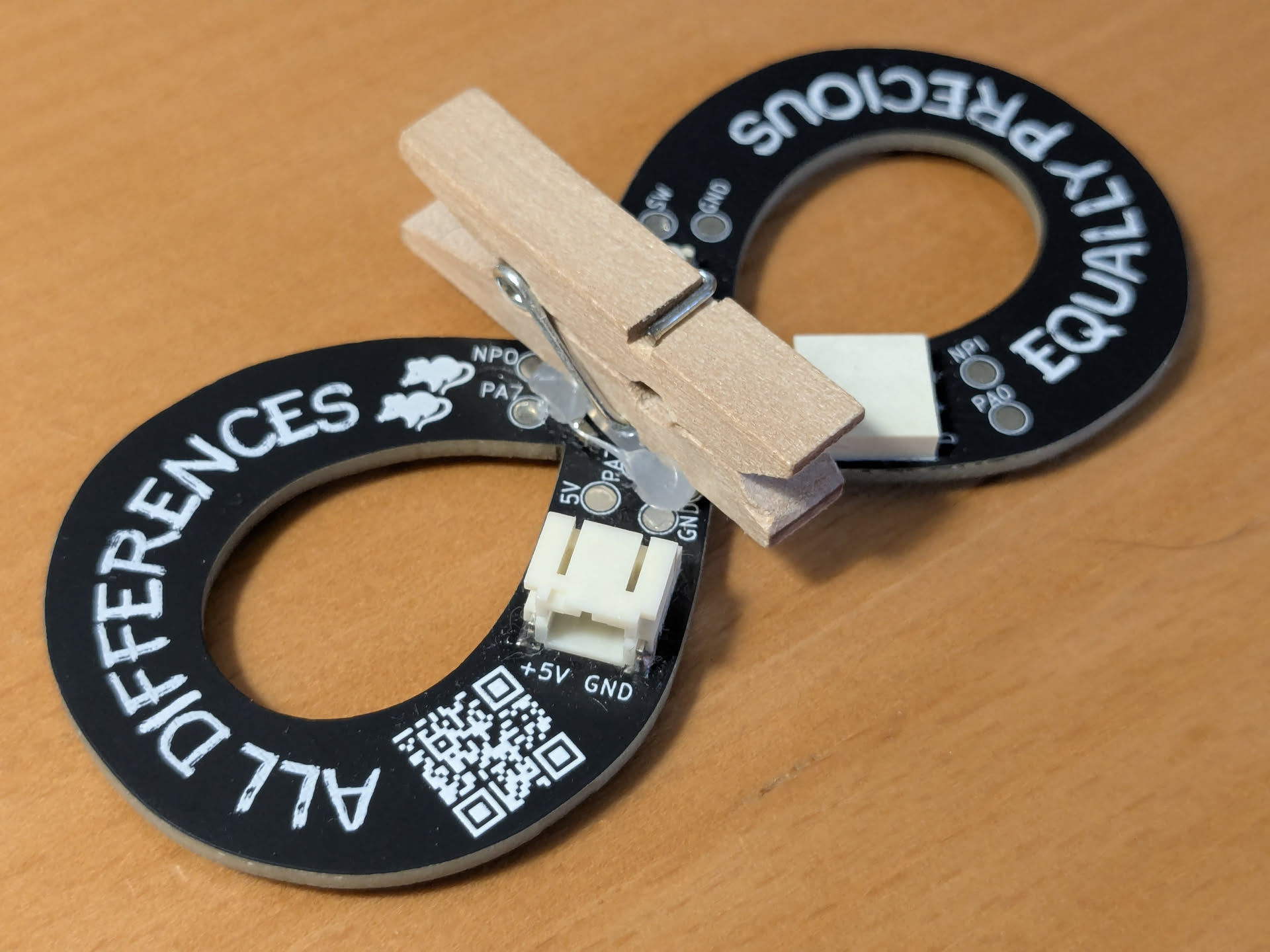 A tiny clothes-pin glued to the back of a badge.